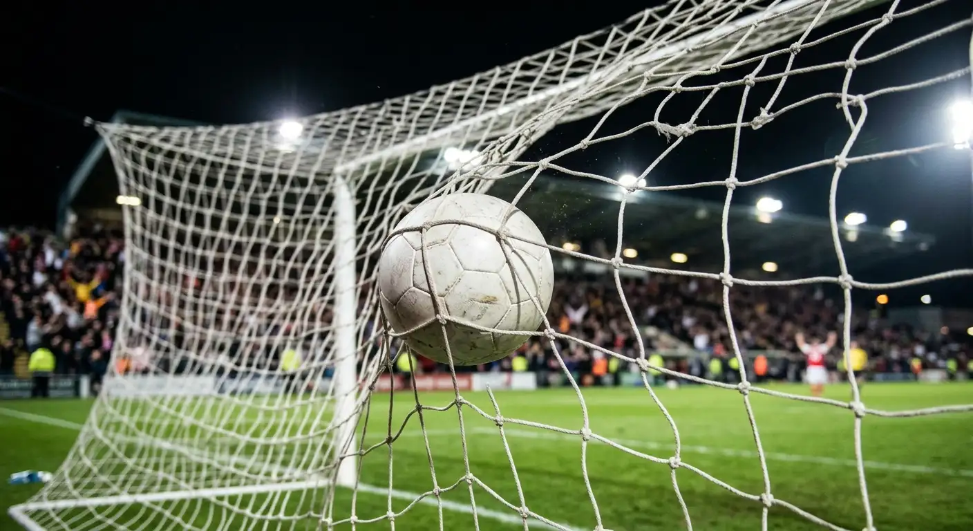 Nærbilde av en fotball i nettmaskene etter en scoring under en kveldskamp